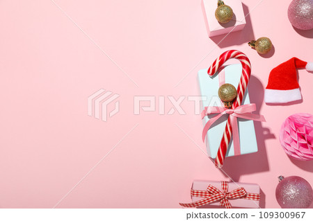 Gift boxes, Christmas candy cane and decorations on pink background, space for text 109300967