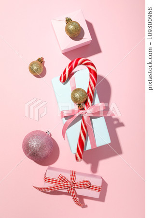 Gift box, Christmas candy cane and balls on pink background, top view 109300968