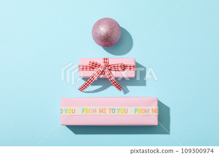 Gift boxes and New Year ball on blue background, top view Gift boxes and New Year ball on blue background, top view 109300974