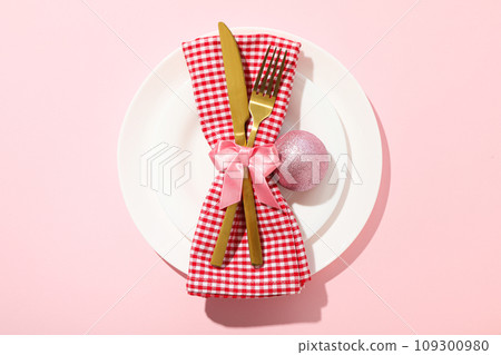 Cutlery and towel on plate on pink background, top view Cutlery and towel on plate on pink background, top view 109300980