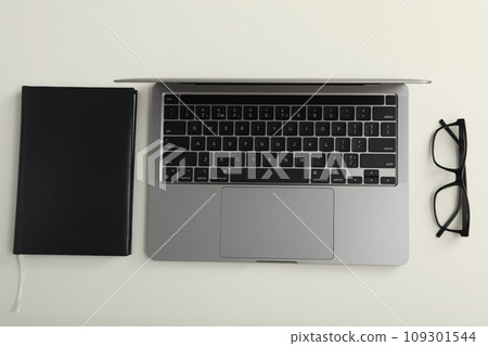 Laptop on table with glasses and notepad 109301544
