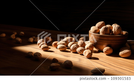 Lifestyle product shot of closed solid nuts, walnuts in a plate on a wooden table. Play light and shadow Lifestyle product shot of closed solid nuts, walnuts in a plate on a wooden table. Play light and shadow 109301583