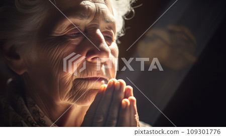 Lifestyle closeup shot of grandma prays, closed eyes, folded hands under the light from the window Play of light and shadow Lifestyle closeup shot of grandma prays, closed eyes, folded hands under the light from the window Play of light and shadow 109301776