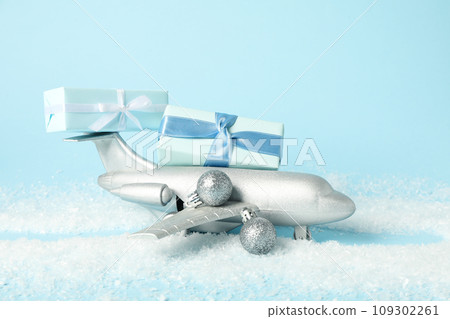 Airplane with gifts and snow on a blue background. Airplane with gifts and snow on a blue background. 109302261