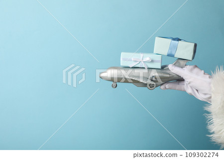 An airplane with gifts in the hands of Santa Claus. 109302274