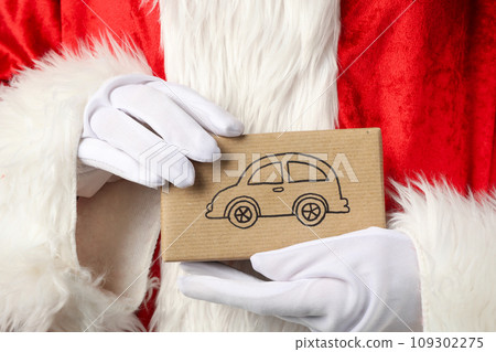 A gift box from a car, in the hand, in Santa Claus. 109302275