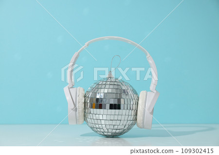 A beautiful disco ball with headphones on a blue background 109302415