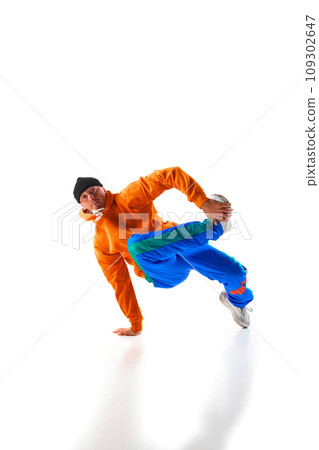 Stylishly dressed man, guy, professional dancer training breakdance freezes, flexing in dace hall in motion against white background. 109302647