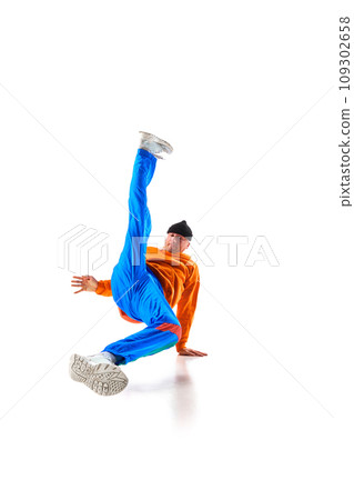 Stylishly dressed man, guy, professional dancer performing freestyle, breakdance elements, flexing against white background. 109302658