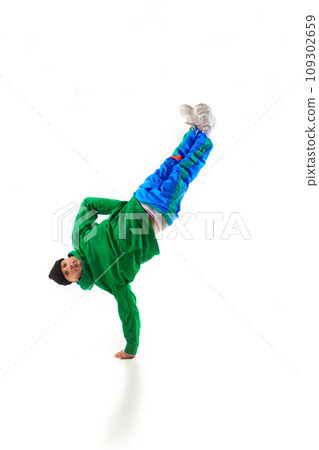 Young sportive man, dude wearing stylishly sport cloth dancing hip-hop, breakdance elements, freezes against white background. Young sportive man, dude wearing stylishly sport cloth dancing hip-hop, breakdance elements, freezes against white background. 109302659