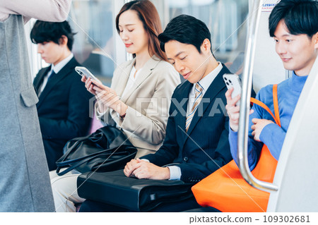 A middle-aged businessman on a commuter train. Photography cooperation: Keio Electric Railway Co., Ltd. 109302681