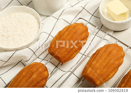 Madeleine cakes, butter and flour in bowls on light background Madeleine cakes, butter and flour in bowls on light background 109302819