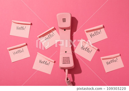 Phone and notes with the word Hello on pink background, top view Phone and notes with the word Hello on pink background, top view 109303220