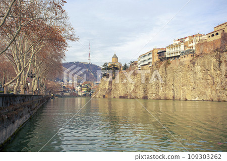 Metekhi church and Houses on the edge of a cliff above the river Kura 109303262