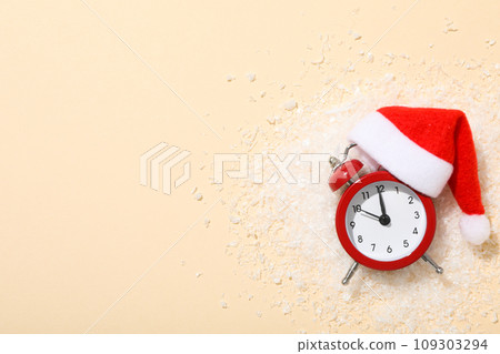A clock with a Santa hat with a New Year's decoration. 109303294