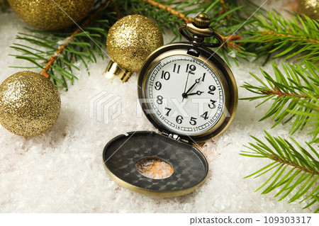 Pocket watch with snow on a light background. 109303317