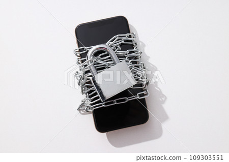 The smartphone is encased in a chain with a lock The smartphone is encased in a chain with a lock 109303551