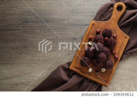 Brigadeiro and hazelnut kitchen board on wooden background, space for text 109303612