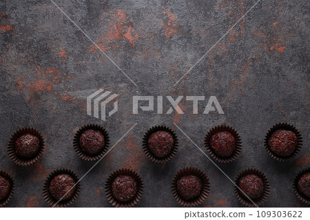 Brigadeiro in paper forms on dark gray background, space for text 109303622