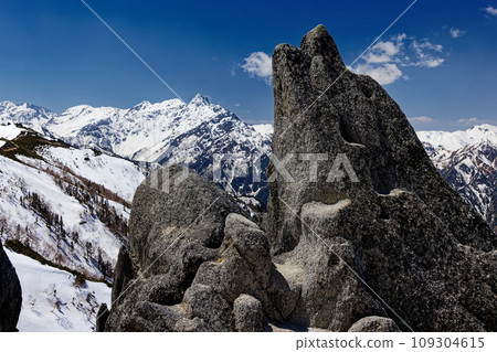Iruka Rock on the Tsubakudake ridgeline in the Northern Alps and Mt. Yarigatake with remaining snow Iruka Rock on the Tsubakudake ridgeline in the Northern Alps and Mt. Yarigatake with remaining snow 109304615