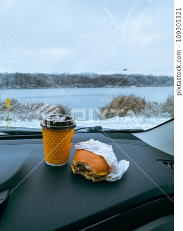 burger and coffee mug at car dashboard burger and coffee mug at car dashboard 109305321