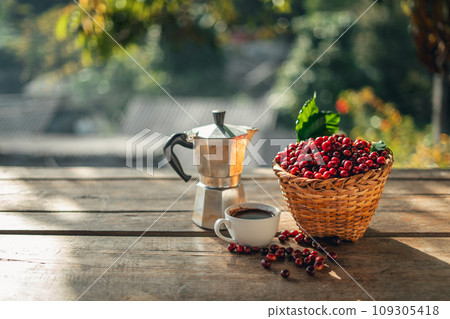 Coffee cherry beans in a basket placed on a wooden table 109305418