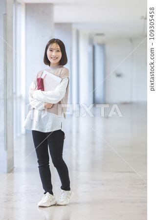 Female college student smiling in the university hallway Photography cooperation: Ariake College of Education and Arts Female college student smiling in the university hallway Photography cooperation: Ariake College of Education and Arts 109305458