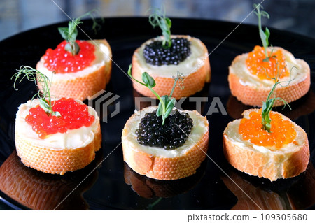 Partitioned dish with black and red caviar on wooden background Partitioned dish with black and red caviar on wooden background 109305680