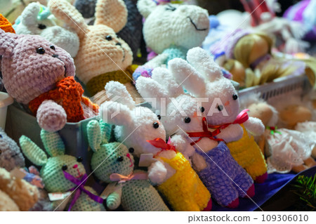 Colorful rabbits, handmade knitted toys lay on the counter 109306010