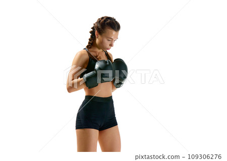 Portrait of strong and athletic woman, professional boxer, sportsman dressed in shorts and gloves posing against white studio background. Portrait of strong and athletic woman, professional boxer, sportsman dressed in shorts and gloves posing against white studio background. 109306276