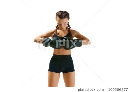 Dynamic and energetic, boxer girl, female professional sportsman in action against white studio background symbolizes power and determination. Dynamic and energetic, boxer girl, female professional sportsman in action against white studio background symbolizes power and determination. 109306277