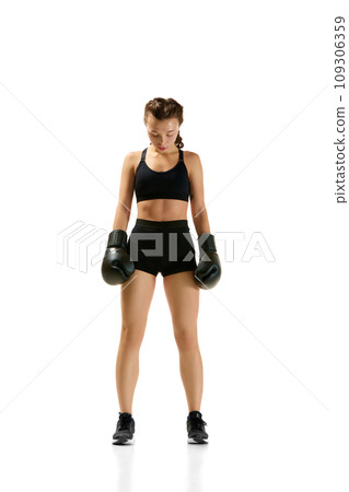 Sporty and powerful, young woman in boxing attire stands out against neutral white studio background. Concept of sport lifestyle, health. Sporty and powerful, young woman in boxing attire stands out against neutral white studio background. Concept of sport lifestyle, health. 109306359