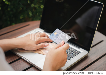 Woman using working and shopping, Online e-commerce, internet banking, Hands of businesswoman holding thai money and credit card on laptop computer, technology finance Woman using working and shopping, Online e-commerce, internet banking, Hands of businesswoman holding thai money and credit card on laptop computer, technology finance 109306632