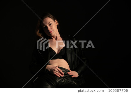 Portrait of a beautiful woman in 40 years old in black clothes in the dark 109307706