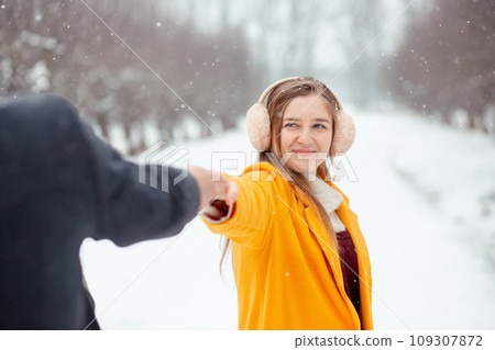 Romantic winter date on the street of couple in love holding hands. Happy couple outdoors in winter. Valentine's Day Romantic winter date on the street of couple in love holding hands. Happy couple outdoors in winter. Valentine's Day 109307872