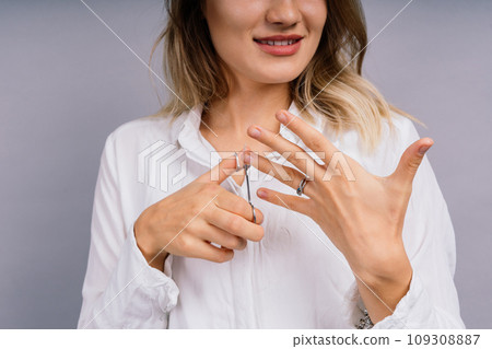Close up young woman have tool cutting nails fingernails on finger using a nail clipper. Close up young woman have tool cutting nails fingernails on finger using a nail clipper. 109308887