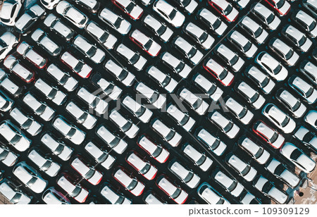 Aerial top down view of new cars parked in car parking lot. Car dealer parking lot full of new automobiles. New cars lined up for import and export business. Aerial top down view of new cars parked in car parking lot. Car dealer parking lot full of new automobiles. New cars lined up for import and export business. 109309129