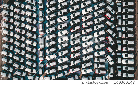Aerial top down view of new cars parked in car parking lot. Car dealer parking lot full of new automobiles. New cars lined up for import and export business. 109309148