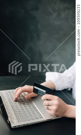 Elegance in E-commerce. Woman's Hands Grasp Credit Card, Navigate Online Shopping with Laptop - Elegance in E-commerce. Woman's Hands Grasp Credit Card, Navigate Online Shopping with Laptop - 109309233