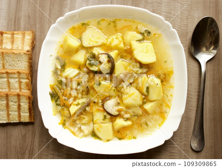 Mushroom soup in a white bowl on a beige background Mushroom soup in a white bowl on a beige background 109309865