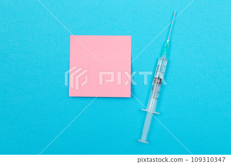 Vaccination or Revaccination Concept - A Medical Syringe on Blue Table Vaccination or Revaccination Concept - A Medical Syringe on Blue Table 109310347