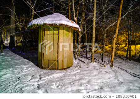 a small wooden house in the forest in winter. round shaped building a small wooden house in the forest in winter. round shaped building 109310401