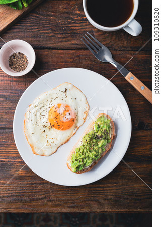Toasts with mashed avocado and fried egg for breakfast Toasts with mashed avocado and fried egg for breakfast 109310820