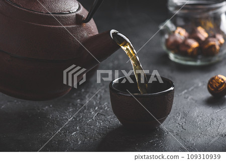 Pouring ready red tea into tea bowl 109310939