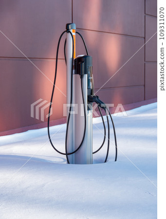 EV charging station for zero emission cars in white snow pile 109311070