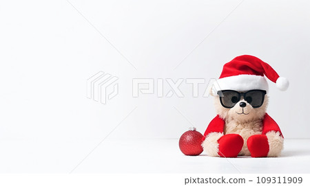 Christmas background with Teddy bear dressed as Santa Claus and red Christmas ball. Teddy bear wearing Santa suit and sunglasses isolated on white with space for text. Christmas background with Teddy bear dressed as Santa Claus and red Christmas ball. Teddy bear wearing Santa suit and sunglasses isolated on white with space for text. 109311909