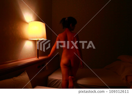 Female nude back pose, body silhouette floating in dark lighting Female nude back pose, body silhouette floating in dark lighting 109312611