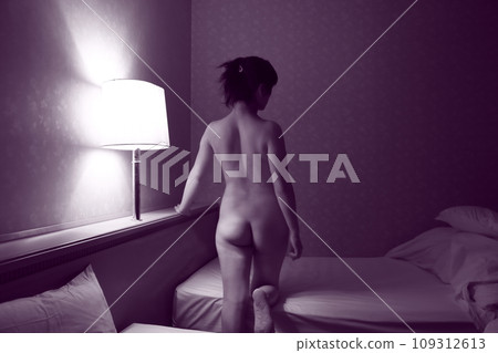 Female nude back pose, body silhouette floating in dark lighting 109312613