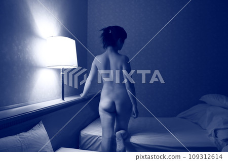 Female nude back pose, body silhouette floating in dark lighting 109312614