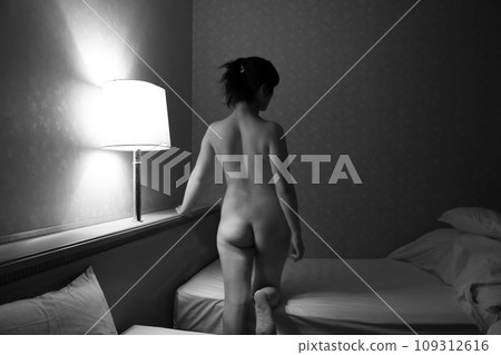Female nude back pose, body silhouette floating in dark lighting 109312616